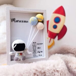 Cadre de naissance, fait main, avec un adorable astronaute en coton crocheté. Chaque section du cadre est personnalisée avec le prénom, la date et l'heure de naissance, le poids et la taille du bébé. Un souvenir et une décoration raffinée pour la chambre de bébé.