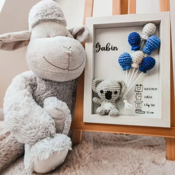 Cadre de naissance, fait main, avec un adorable koala en coton crocheté. Chaque section du cadre est personnalisée avec le prénom, la date et l'heure de naissance, le poids et la taille du bébé. Un souvenir et une décoration raffinée pour la chambre de bébé.