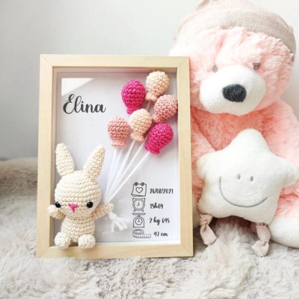 Cadre de naissance, fait main, avec un adorable lapin en coton crocheté. Chaque section du cadre est personnalisée avec le prénom, la date et l'heure de naissance, le poids et la taille du bébé. Un souvenir et une décoration raffinée pour la chambre de bébé.