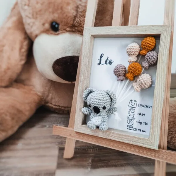 Cadre de naissance, fait main, avec un adorable koala en coton crocheté. Chaque section du cadre est personnalisée avec le prénom, la date et l'heure de naissance, le poids et la taille du bébé. Un souvenir et une décoration raffinée pour la chambre de bébé.