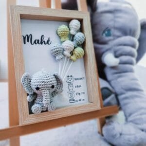 Cadre de naissance, fait main, avec un adorable éléphant en coton crocheté. Chaque section du cadre est personnalisée avec le prénom, la date et l'heure de naissance, le poids et la taille du bébé. Un souvenir et une décoration raffinée pour la chambre de bébé.