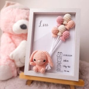 Cadre de naissance, fait main, avec un adorable lapin aux longues oreilles en coton crocheté. Chaque section du cadre est personnalisée avec le prénom, la date et l'heure de naissance, le poids et la taille du bébé. Un souvenir et une décoration raffinée pour la chambre de bébé.