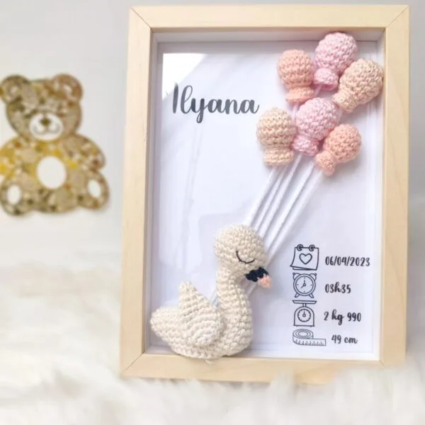 Cadre de naissance, fait main, avec un adorable cygne en coton crocheté. Chaque section du cadre est personnalisée avec le prénom, la date et l'heure de naissance, le poids et la taille du bébé. Un souvenir et une décoration raffinée pour la chambre de bébé.