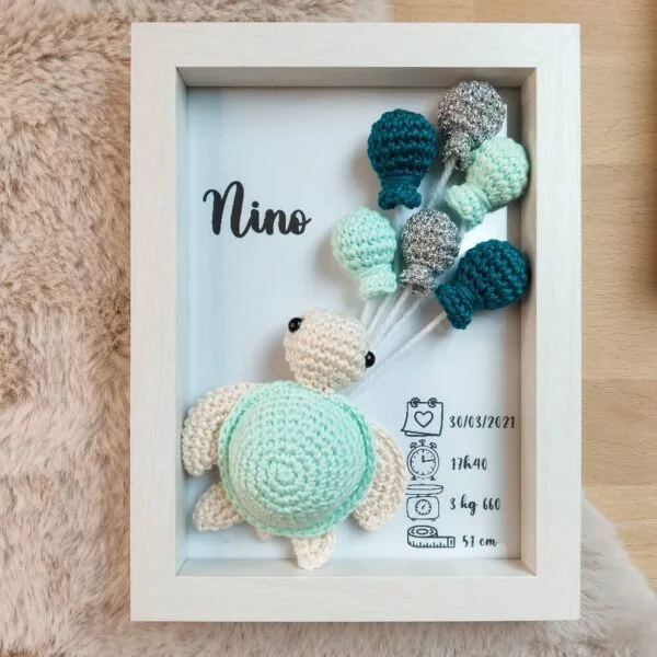 Cadre de naissance, fait main, avec une adorable tortue en coton crocheté. Chaque section du cadre est personnalisée avec le prénom, la date et l'heure de naissance, le poids et la taille du bébé. Un souvenir et une décoration raffinée pour la chambre de bébé.